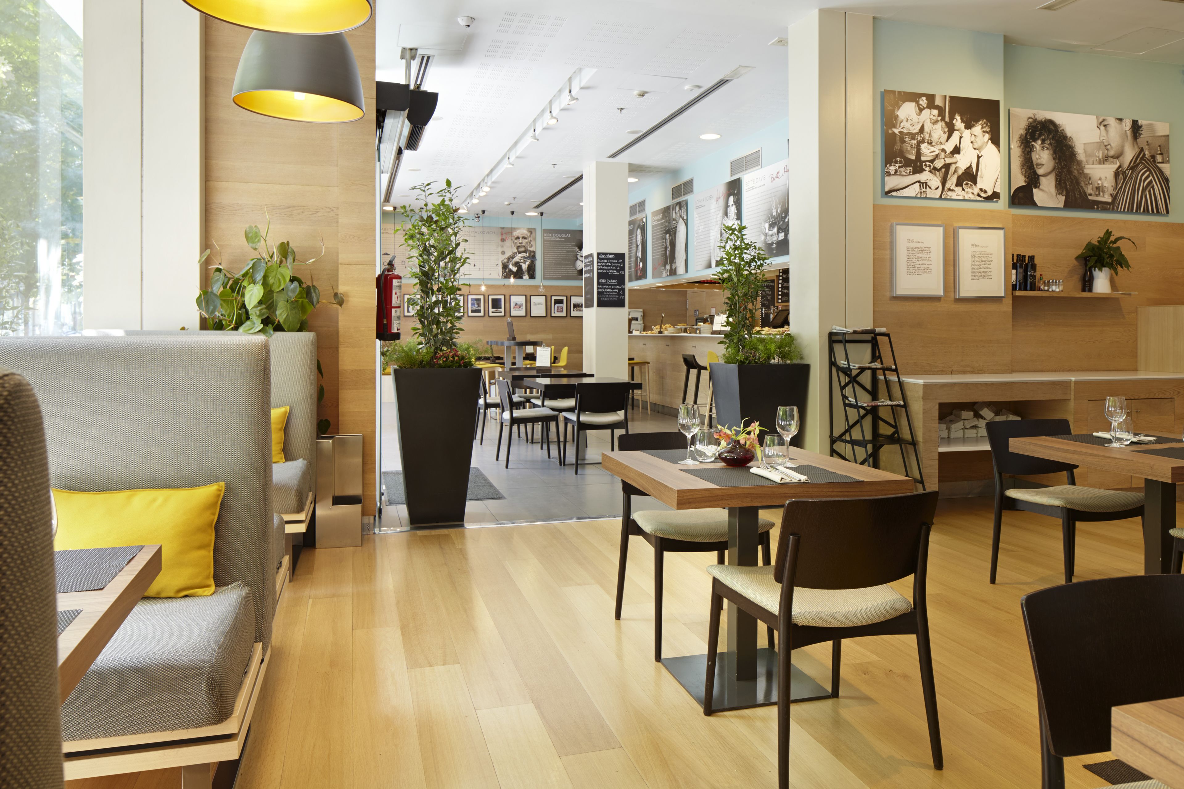 A modern hotel lobby with seating areas, a bar, and artwork on the walls.