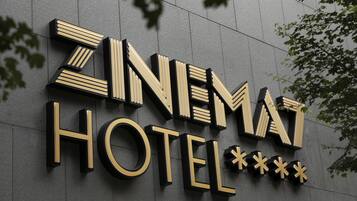 A hotel sign with the name "ZINEMAT HOTEL" in bold, stylized letters.