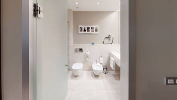 Ein modernes Badezimmer mit Toilette, Bidet und Waschbecken.