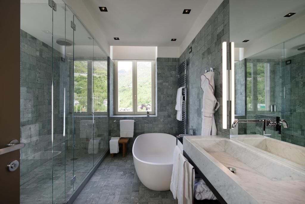 A modern bathroom with a freestanding bathtub, a glass-enclosed shower, and a large mirror.