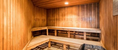 A sauna with wooden benches and a stone floor.