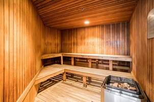 Una sauna con bancos de madera y suelo de piedra.