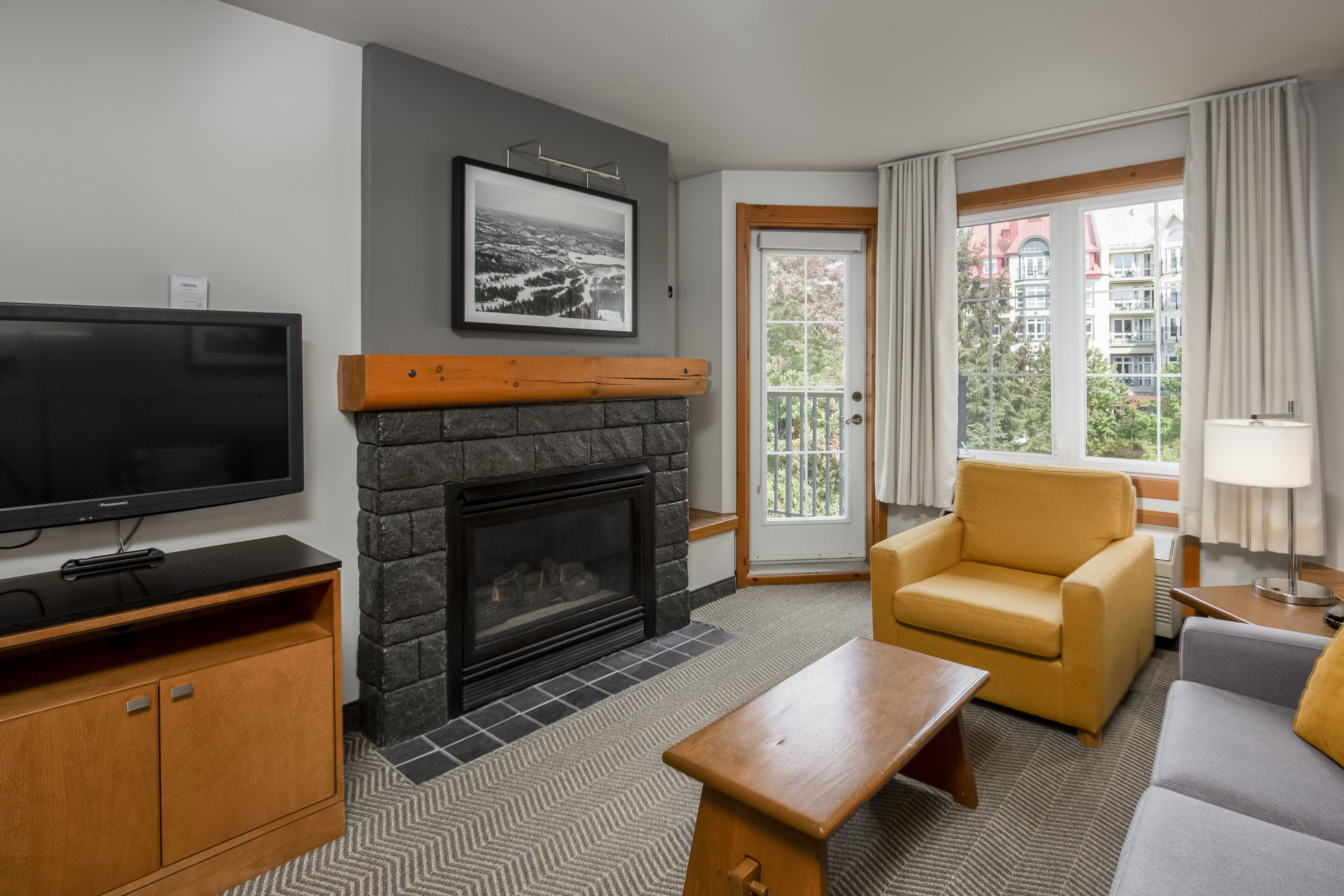 Una sala de estar moderna con chimenea, televisor, sofá y sillón.