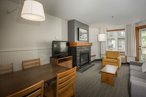 Una sala de estar moderna con chimenea, televisor y zonas de estar.