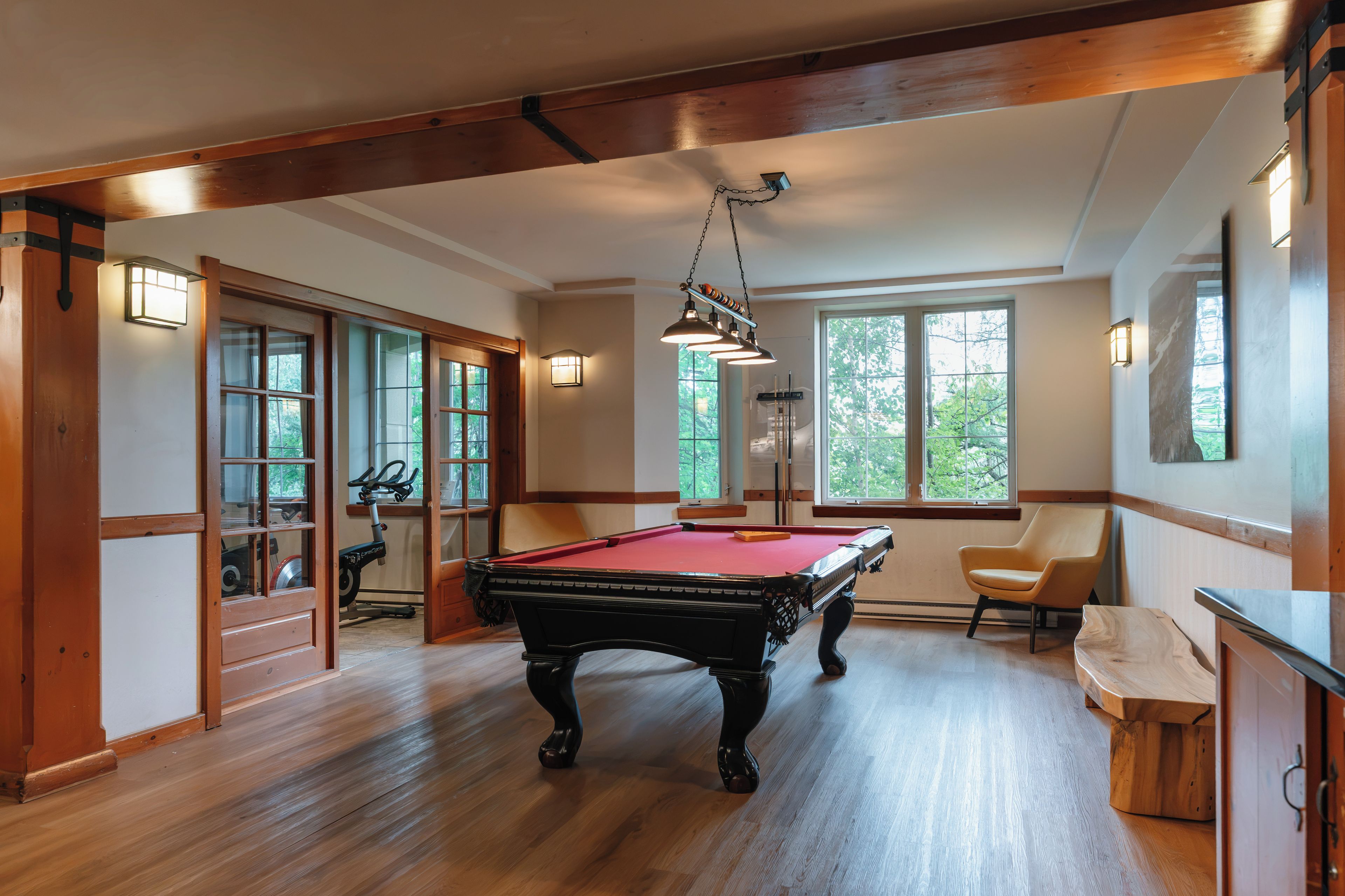 A spacious room with a pool table, a bicycle, and a chair.
