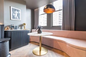 Una sala de estar moderna con un sofá curvo, una mesa redonda y una lámpara colgante.