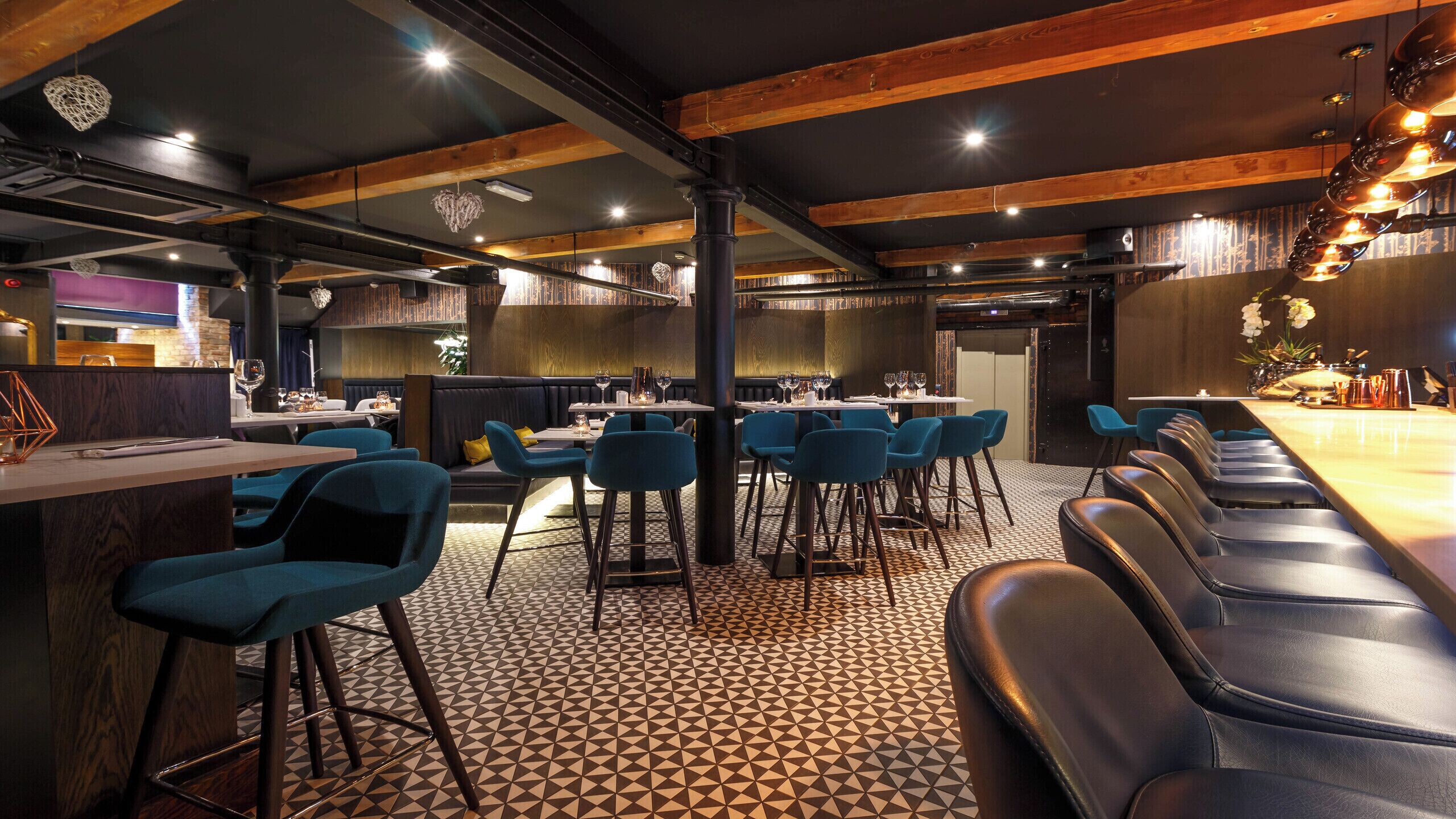 A restaurant with a bar area, booths, and high stools.
