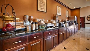 Un buffet de petit-déjeuner d’hôtel proposant une grande variété d’aliments, des machines à café et un élégant comptoir en marbre poli.