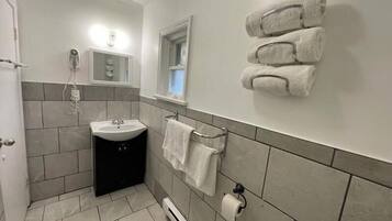 Ein Badezimmer mit Waschbecken, Handtuchhalter und Toilettenpapierhalter.