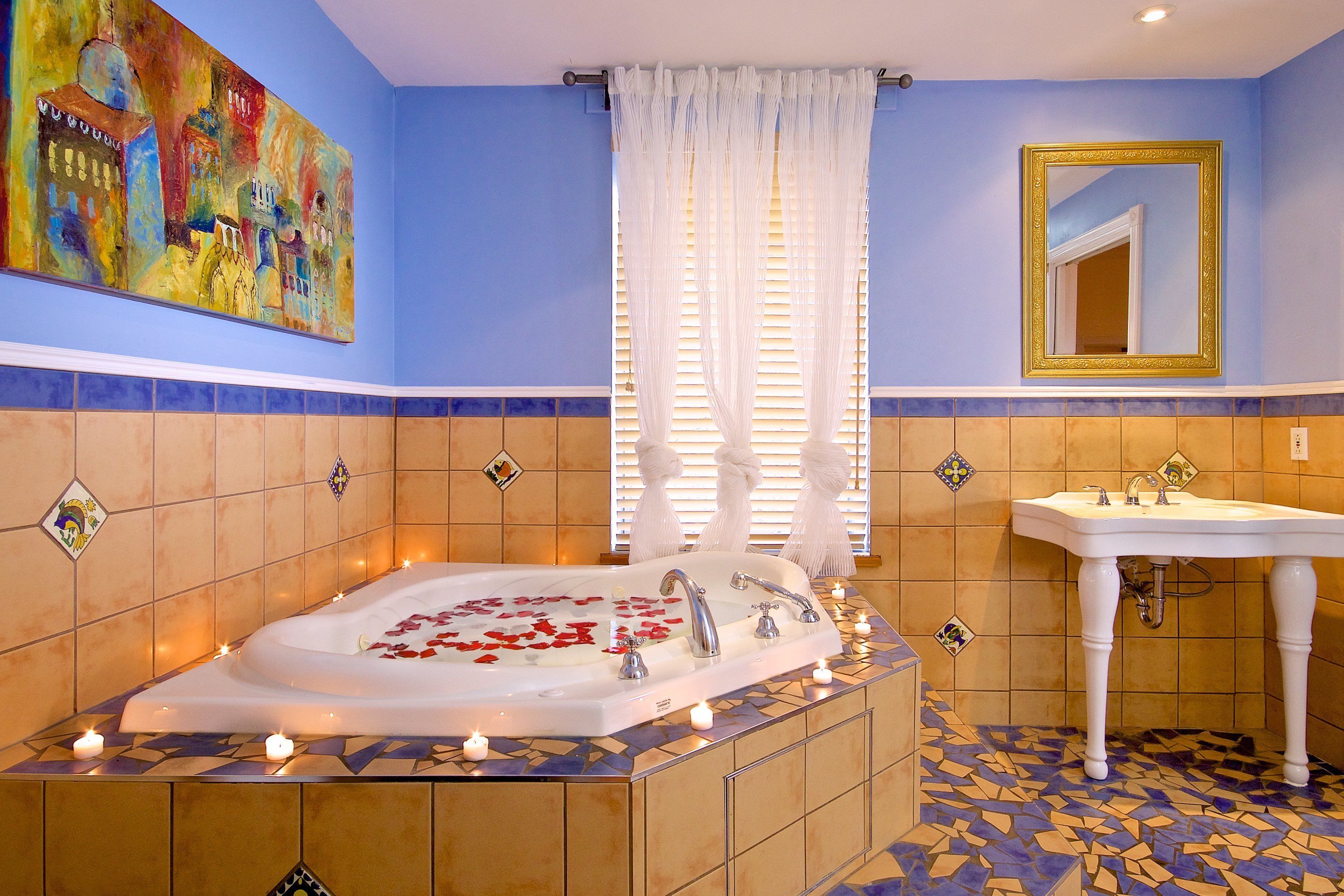 A bathroom with a large bathtub, a white sink, and a mirror.