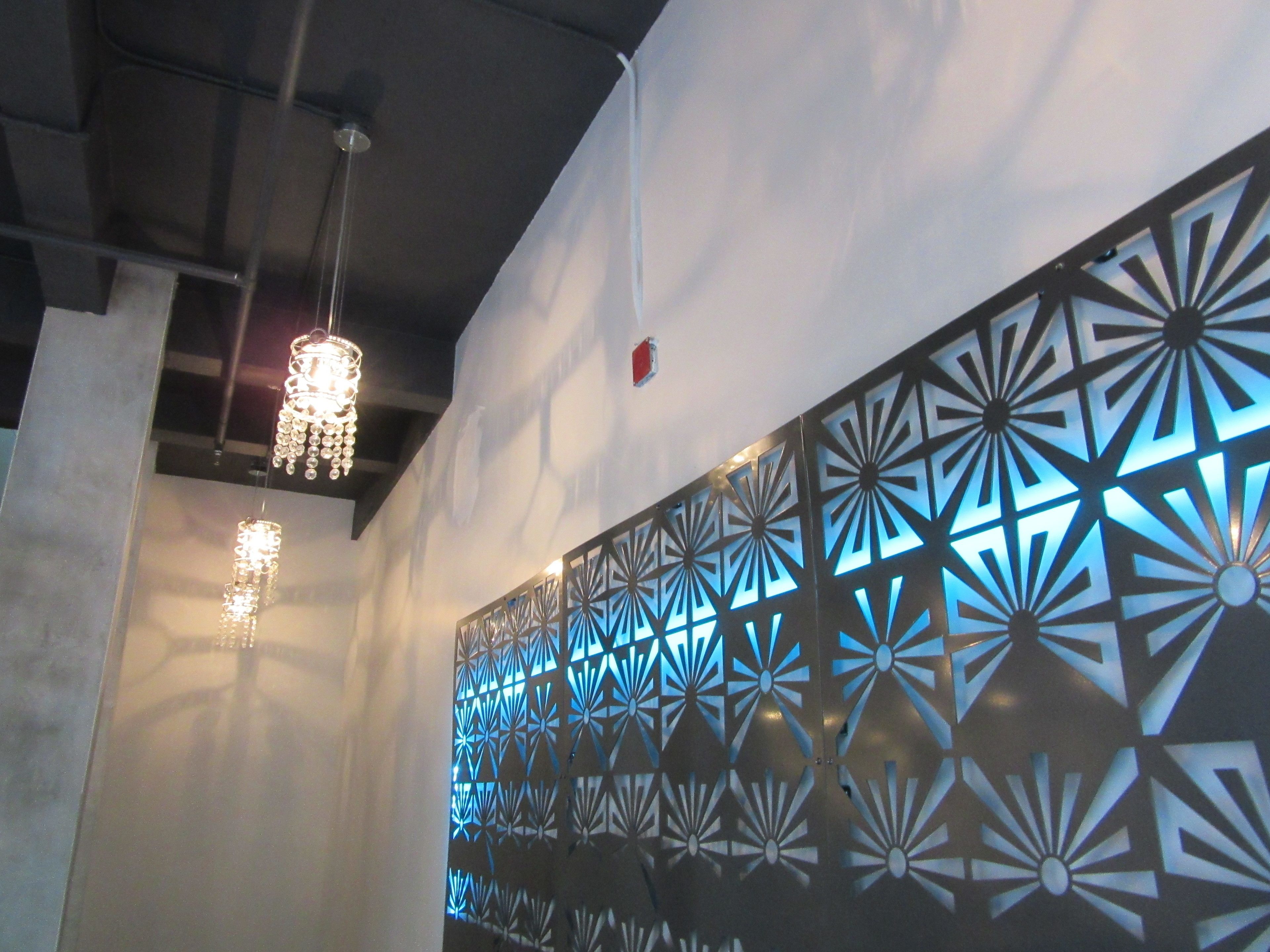 A modern interior with geometric wall patterns and hanging crystal chandeliers.