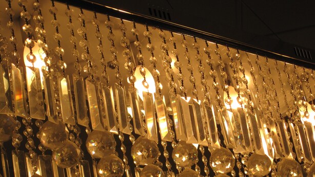 Un candelabro con múltiples detalles de cristal y lámparas.