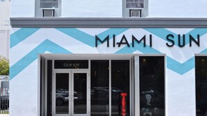 Un edificio con un diseño en forma de V y el nombre "MIAMI SUN" en la fachada.