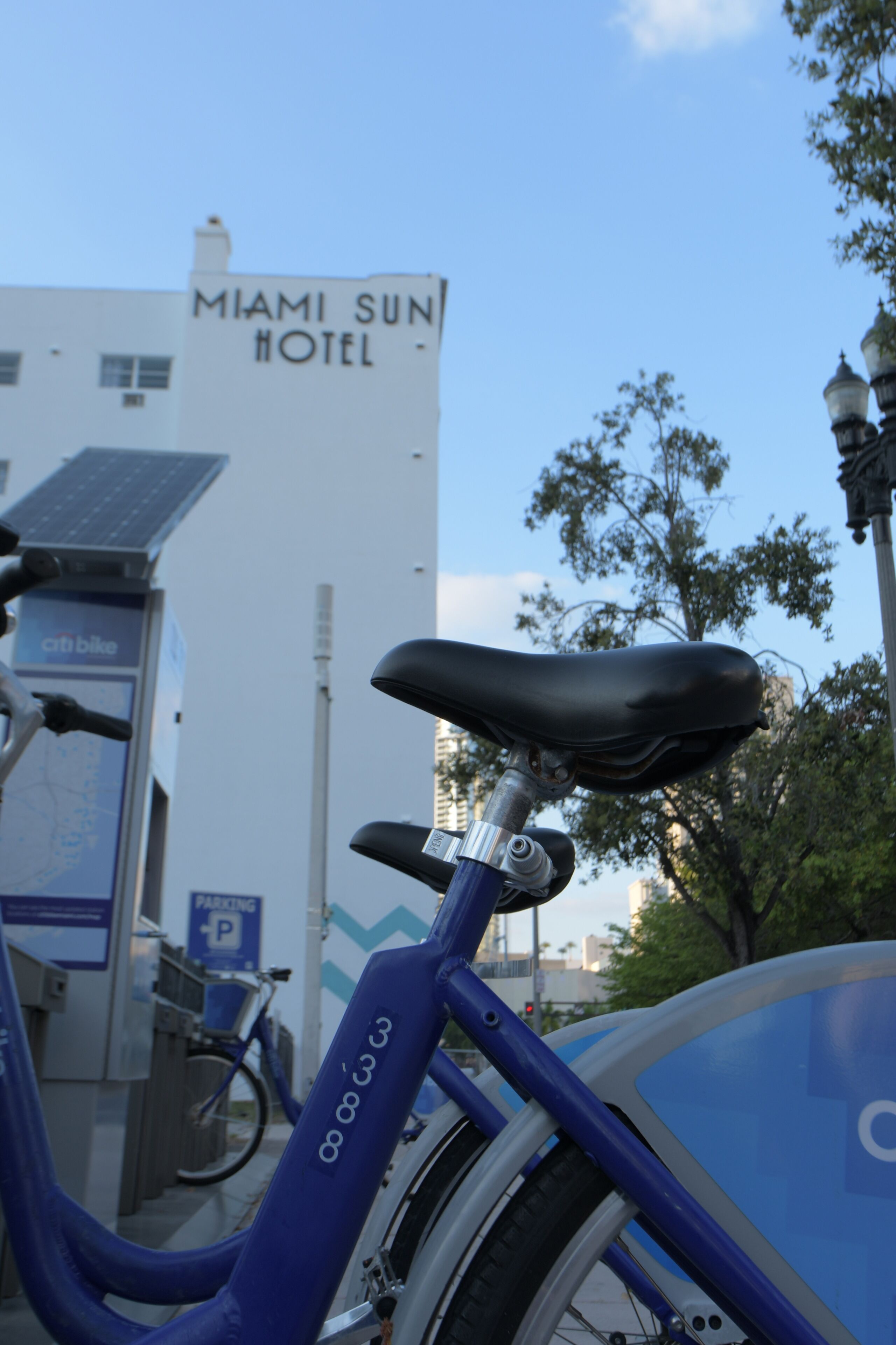A bicycle parked in front of a building labeled "Miami Sun Hotel".