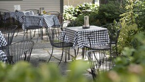 An outdoor patio with checkered tablecloths and metal chairs. - Norwich Inn (Norwich)