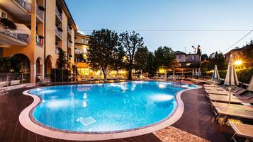 Una piscina al aire libre de temporada, sombrillas