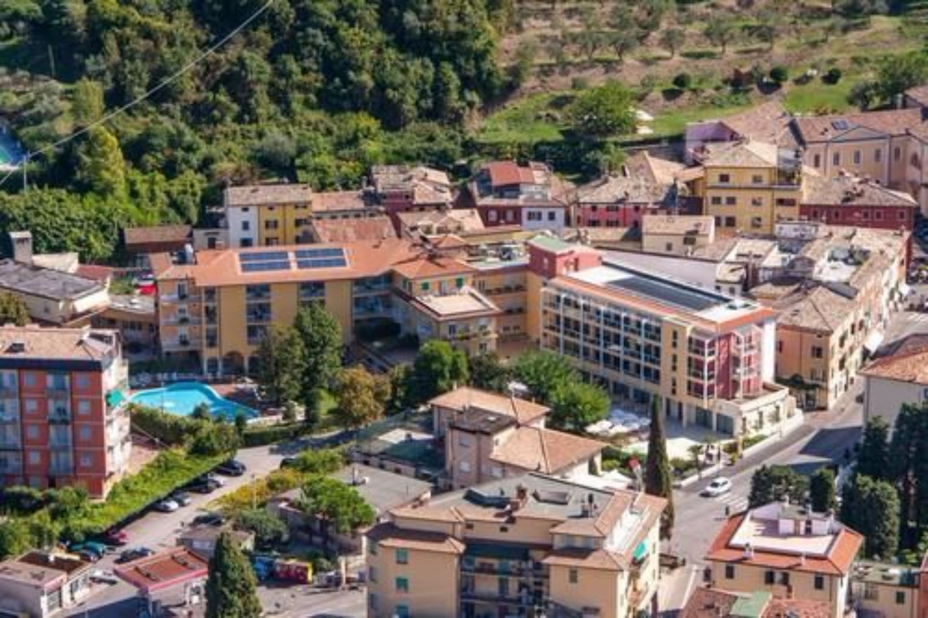 Un pueblo con una mezcla de edificios residenciales y comerciales, incluyendo un hotel con piscina.