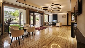 A modern hotel lobby with a polished wooden floor, a reception desk, and a seating area with chairs and a table. - Hotel Bisesti (Garda)