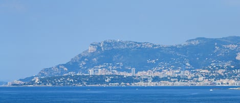 A coastal cityscape with a prominent mountain in the background.