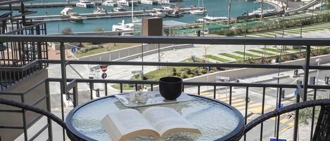 A balcony with a table, chairs, and an open book.