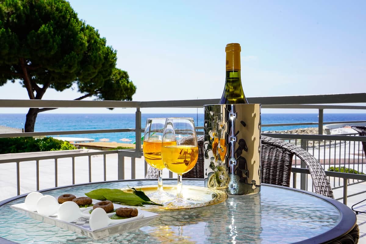 Une table avec une bouteille de vin, deux verres et un plateau contenant de la nourriture et des boissons.
