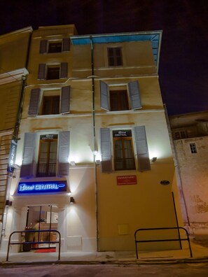 Un hotel con varios pisos, un cartel que indica 'Hotel Central' y un cartel que dice 'Ouverture'.