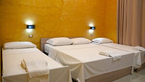 A hotel room with two single beds, each with a white bedspread and pillows, and a pair of towels. - Ferrari (Rome)
