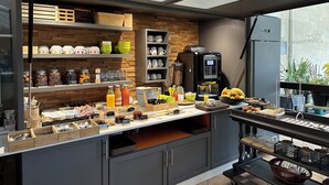 A modern kitchen with a coffee machine, shelves with kitchenware, and a variety of food items. - LOGIS Hostellerie des Ducs (Duras)