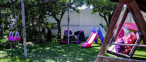 A playground with swings, slides, and a swing set.