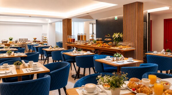 A hotel dining area with multiple tables, chairs, and a buffet with various food items.