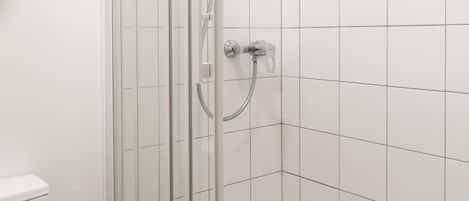 Une salle de bain moderne avec une douche à parois de verre, des carreaux blancs et des toilettes apparentes.