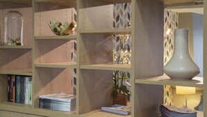 Una estantería de madera con varios objetos decorativos y libros.