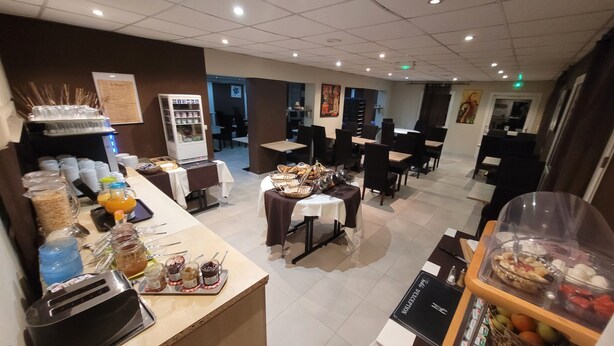 A hotel dining area with buffet stations, tables, and chairs.