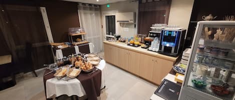 A buffet setup with various food items and a coffee machine.