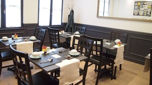 A dining area with multiple tables and chairs, arranged in a U-shape. - Hôtel Colbert Tours (Tours)