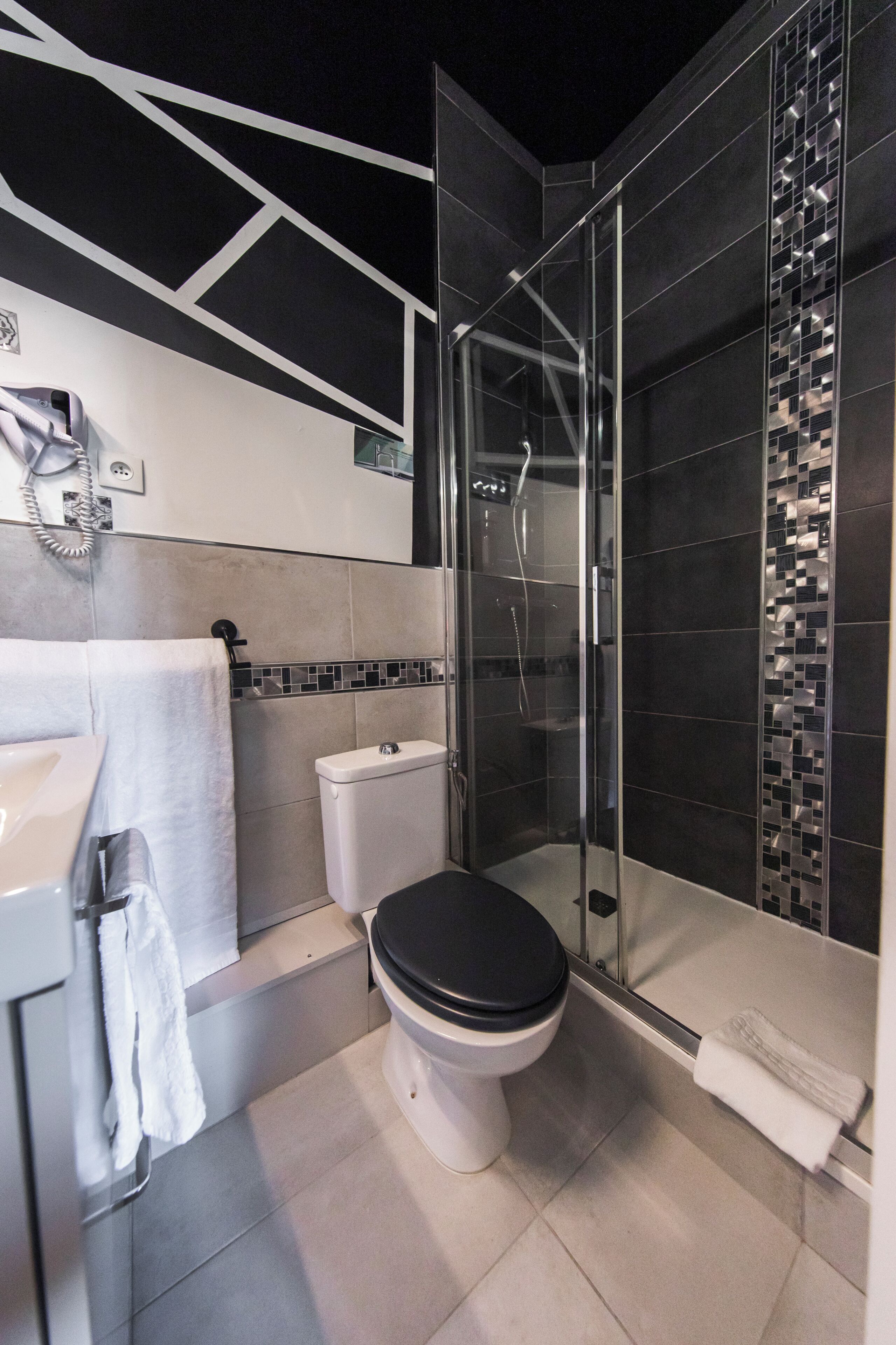 Une salle de bain moderne équipée de toilettes, d’une douche et d’un lavabo.