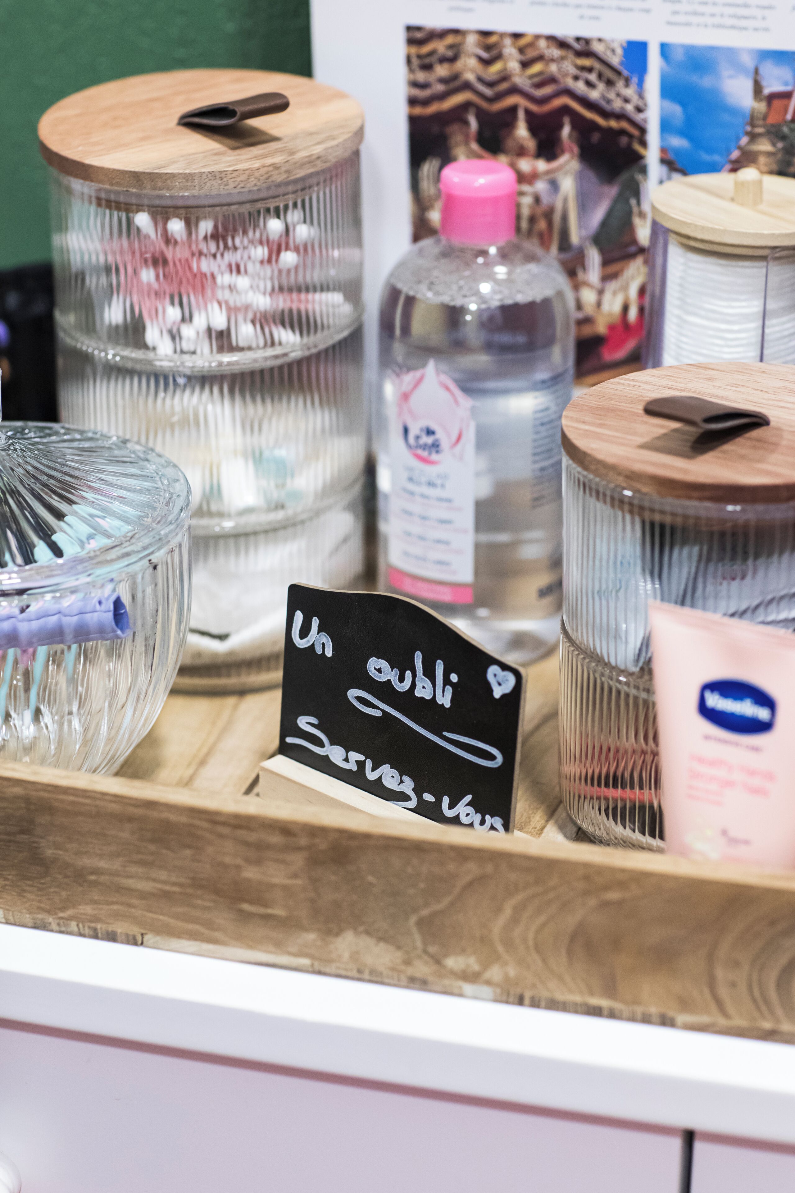 Verschiedene Behälter mit Deckeln, darunter Glasgläser und Plastikflaschen, sind auf einer Holzoberfläche angeordnet.