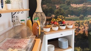 A breakfast buffet with various food items, a decorative vase, and a mural of hot air balloons. - Hotel Mondial (Tours)