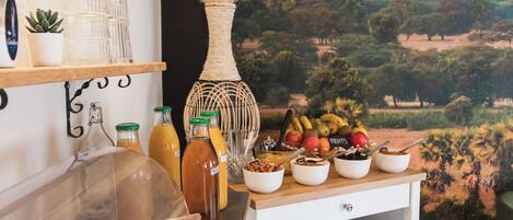 A breakfast buffet with various food items, a decorative vase, and a mural of hot air balloons.