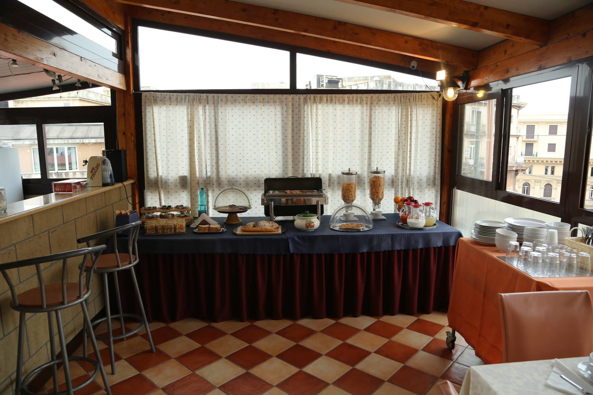 Un buffet de petit-déjeuner proposant une grande variété d’aliments, une machine à café et une vue magnifique grâce à de grandes fenêtres.