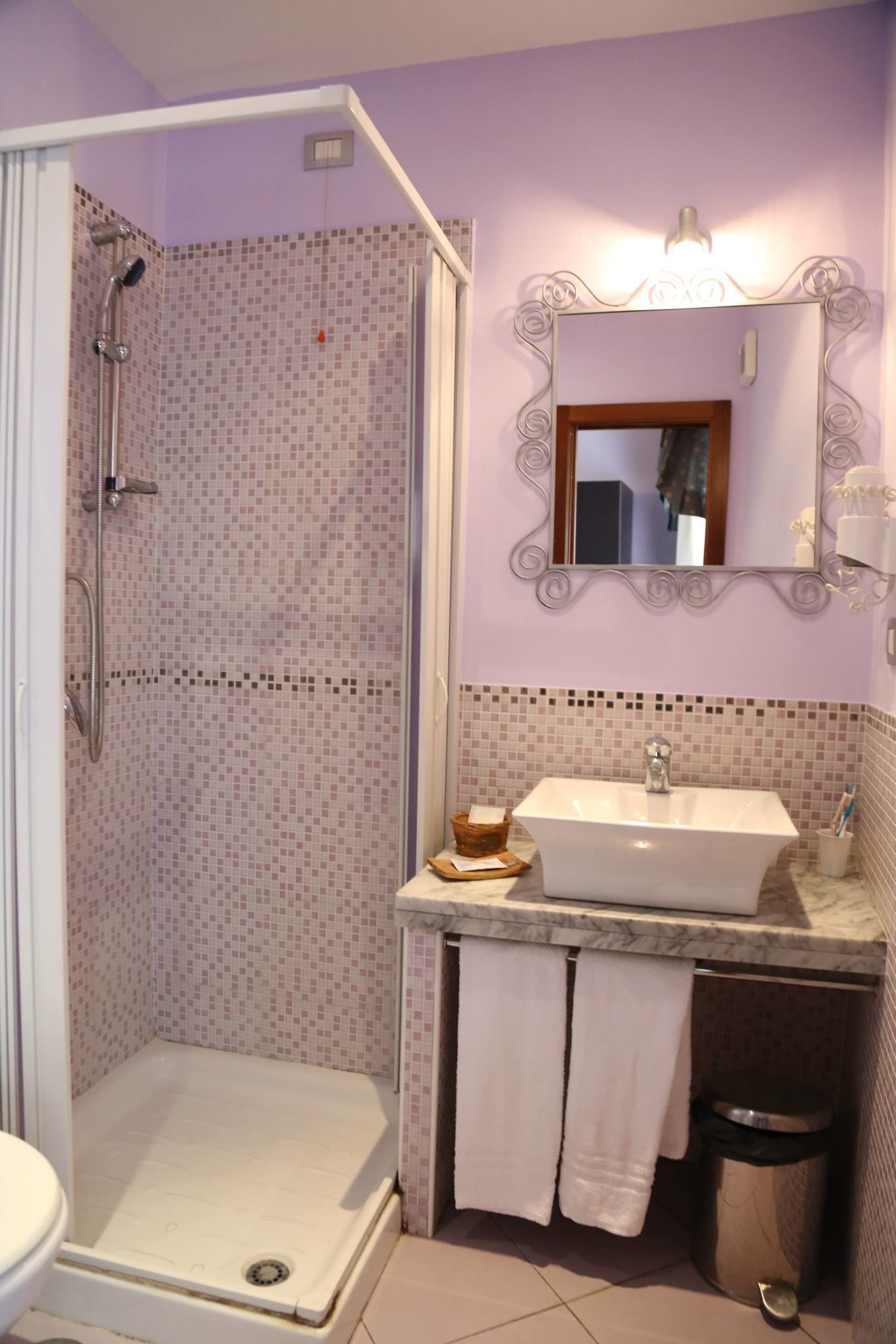 A bathroom with a shower, sink, and mirror.