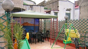 Un patio con una mesa, sillas, un tobogán y un columpio.