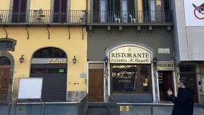 A building with multiple windows, a storefront labeled "RISTORANTE PIZZERIA H. Bargello," and a person standing on the sidewalk.