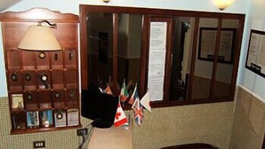 A room with a wooden desk, a lamp, a leather sofa, and multiple flags. - Vittorio Veneto (Naples)