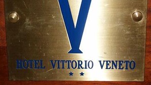 A metal plaque with a large blue 'V' and the text 'HOTEL VITTORIO VENETO'. - Vittorio Veneto (Naples)