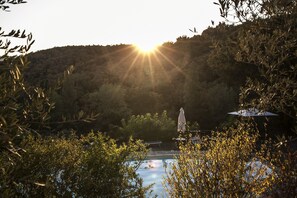 A pool with a statue in the center, surrounded by trees and hills. - Borgo Casa al Vento (Gaiole in Chianti)