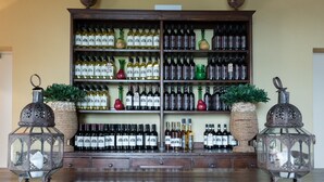 A bar area with a wooden counter, shelves of wine bottles, and decorative lanterns. - Podere Torricella (Montespertoli)