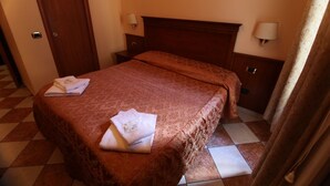 A hotel room with a bed, two bedside tables, and a door. - Hollywood Roma (Rome)