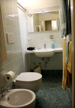 A bathroom with a toilet, sink, and mirror. - Gianna's B&B (Florence)