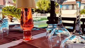 Une table est dressée avec différents types de verres, notamment un verre haut et élancé et un verre court et large, le tout posé sur une nappe.
